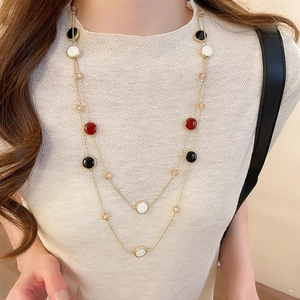 Collier double rang doré avec pendentifs en résine colorée porté par un mannequin