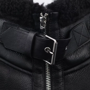 Detailed close-up of a black leather jacket collar with shearling lining and metal buckle