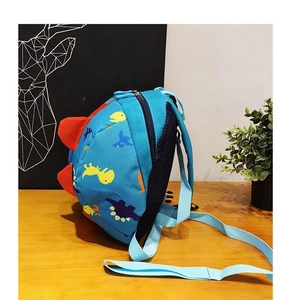 Detailed side view of blue dinosaur backpack with 3D fins and breathable mesh back pads