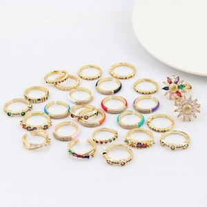 Vista detallada de anillos de oro con circonitas de colores y motivos de esmalte