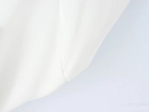 Close-up of smooth white silk fabric texture showing elegant drape and soft luster