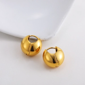 Detailed view of polished 18K gold spherical chunky hoop earrings with mirror finish