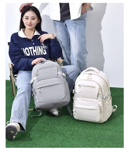 Detail of grey and off-white multi-pocket nylon backpacks shown in a casual lifestyle setting