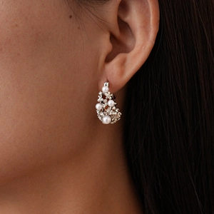 Detailed view of silver hoop earrings with cluster pearls and sparkling rhinestones