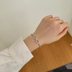Close-up of S925 silver Mobius bracelet with sparkling cubic zirconia on female wrist
