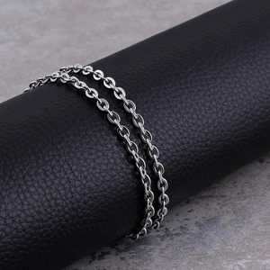 Minimalist stainless steel O-link chain necklace wrapped on a black leather display stand