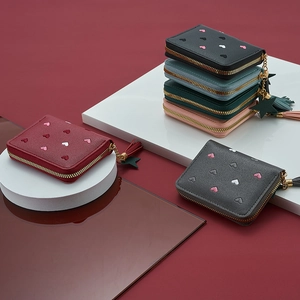 Detail of elegant heart embroidery and tassel star zipper on various short wallets