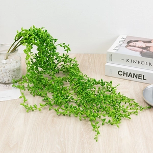 Close-up of artificial hanging succulent vines in a minimalist Nordic interior setting