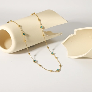 18K gold plated stainless steel necklace with blue evil eye beads and small gold spheres