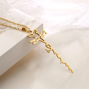 Detailed view of custom gold script pendant necklace on elegant white lace background