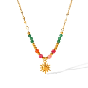 Close-up of beaded necklace with gold sun pendant and colorful natural stones