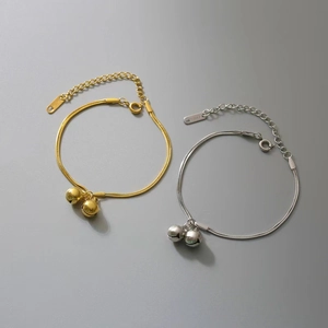 Detail of titanium steel bell pendants and lobster clasp on a layered snake chain