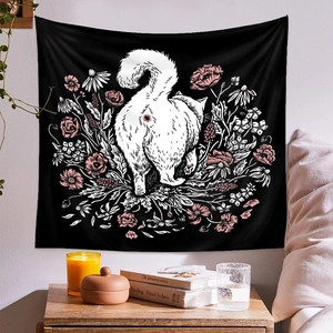 Detailed view of cat and floral wall tapestry hanging in a cozy minimalist bedroom scene