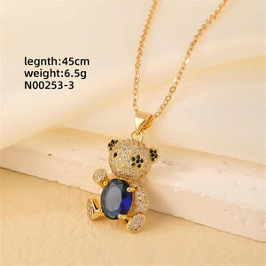 Detail of gold teddy bear pendant with micro-paved zircons and blue oval gemstone