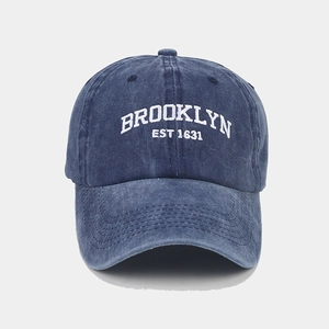 Close-up of white Brooklyn EST 1631 embroidery on navy washed cotton baseball cap