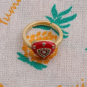 Close-up of golden adjustable ring with red heart enamel and colorful zircon eye motif