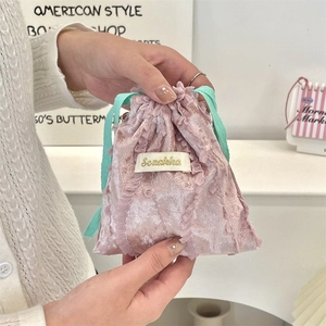 Close-up of pink velvet drawstring pouch with delicate lace trim and soft texture
