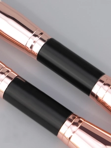 Detail of rose gold metal ferrules and black glossy handles on makeup brushes