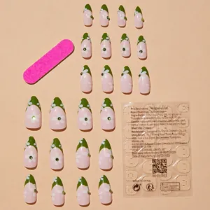 Sweet pink floral press-on nails set with green rhinestones and manicure accessories