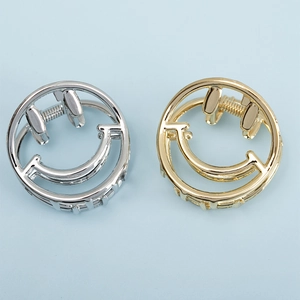 Detail of round smiley face metal hair clips in gold and silver finish for hair styling