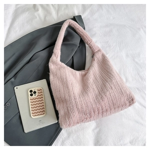 Detailed close-up of a pink faux fur tote bag showing plush texture on a chic blazer