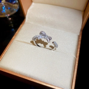 Macro shot of silver bow ring with sparkling zircons and pearls in an orange gift box