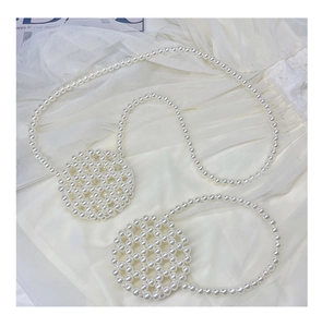 Detail of beaded acrylic pearl crossbody bags with shoulder straps on white lace fabric