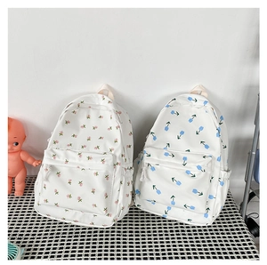 Detail of floral canvas backpacks featuring pink flowers and blue tulips on white fabric