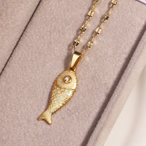Detailed close-up of a gold koi fish pendant with shimmering texture in a beige jewelry box