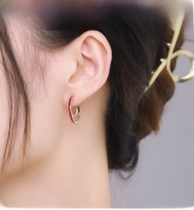 Detail of S925 silver double hoop earrings with red enamel and pavé zircon on model