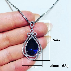 Elegant pear-shaped blue sapphire pendant necklace with bow accent, dimensions 32mm x 17mm