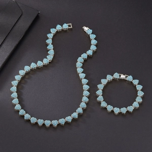 Macro detail of silver necklace and bracelet set with light blue heart rhinestones
