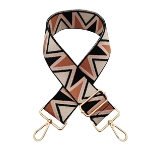 Detail of adjustable geometric zigzag woven bag strap with polished gold-tone metal clips