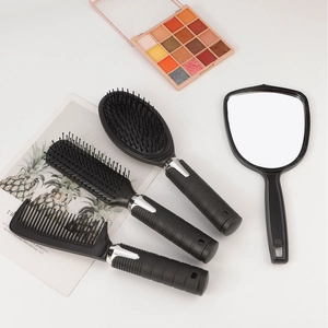 Detailed view of 4-piece hairbrush set in matte black finish with hand mirror