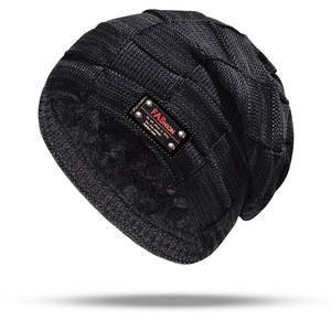 Detail of gray knitted hat with thick fleece lining and leather fashion patch