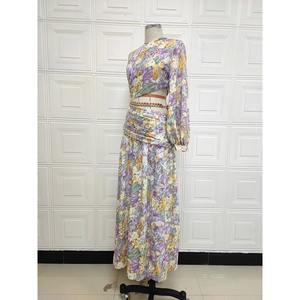 Detailed view of floral one-shoulder long sleeve top and matching pleated maxi skirt set