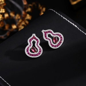 Macro shot of wulu earrings with red gemstone and white zircon in silver plating