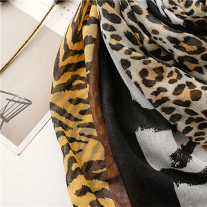 Detail of color-block zebra and leopard print scarf with fine stitched edge and texture