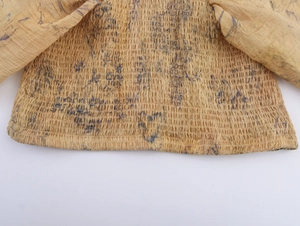 Close-up of yellow smocked fabric texture on long sleeve top with elastic pleats