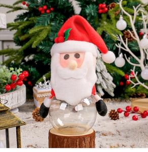 Close-up of a Santa Claus transparent candy jar on a rustic wood base with holiday decor