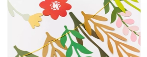 Detailed macro view of colorful paper flower banners with red petals and green leaves