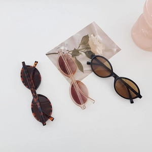 Detailed view of trendy oval sunglasses in black, tortoiseshell and tea pink finishes