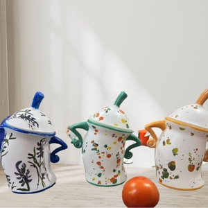 Three ceramic canisters with blue floral and colorful polka dots on a wooden table