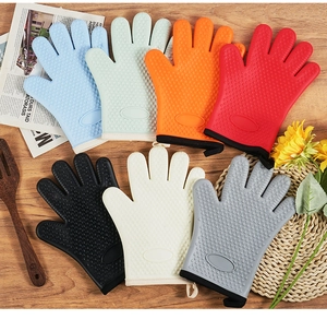 Silicone oven mitts with non-slip heart texture in various colors on wooden table