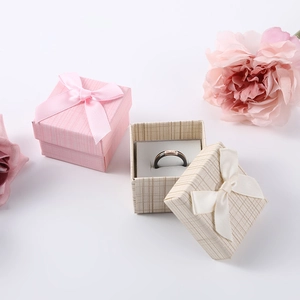 Pink and beige square jewelry gift boxes with ribbon bows and interior ring insert
