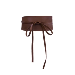 Detailed view of a brown faux leather wide waist belt with a stylish tie-up bow closure