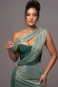 Détail du tissu métallique vert sur une robe de soirée asymétrique à coupe corsetée