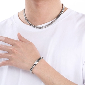 Sleek silver titanium steel Cuban link chain necklace and bracelet set on model