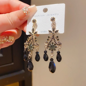 Close-up of vintage gold tassel earrings with dark crystals and 925 silver pins