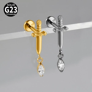 Macro shot of G23 titanium sword pendants in gold and silver with marquise stones